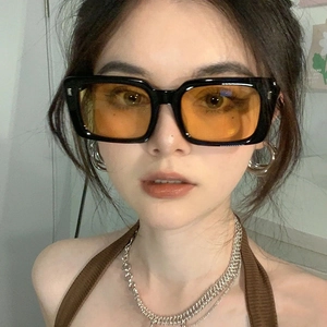 Retro rectangle sunglasses with black frame and orange lenses worn by a fashion model