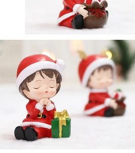 Vue macro d'une figurine de fille en prière pour déco de Noël avec lumières bokeh