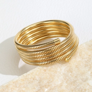Close-up of golden multi-layer coil bracelet with fine spiral snake bone texture