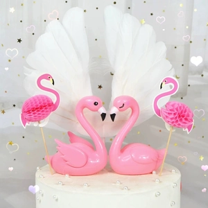Detail of pink flamingo cake toppers and white feather wing decorations for dessert