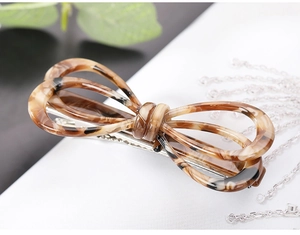 Macro shot of French acetate bow hair clip with leopard print and silver metal base