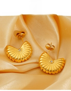 Détail de boucles d'oreilles en acier titane doré en éventail avec texture striée