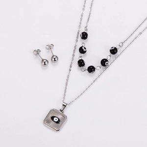 Detail of silver stainless steel jewelry set featuring evil eye pendant and beaded necklace