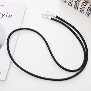 Detail of black leather crossbody phone strap with premium silver metal clasp hardware