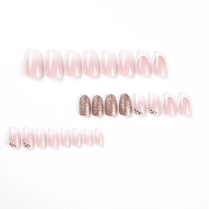 French tip press-on nails with rose gold glitter and rhinestones in almond shape