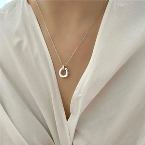 Close-up of a 925 sterling silver geometric round pendant necklace worn by a model