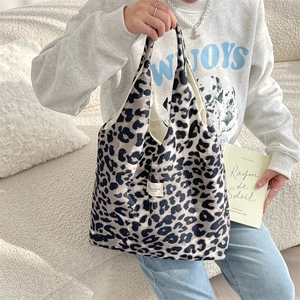 Detail of trendy leopard print fabric tote bag with minimalist label and soft texture