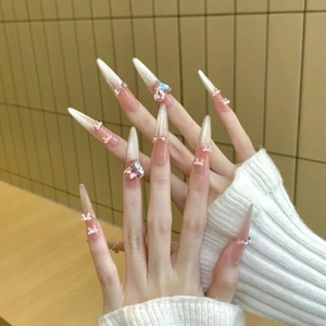Long stiletto press-on nails with champagne cat-eye glitter, bows, and pink heart crystals
