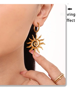 Detail showing wearing effect of sun totem charm earrings and gold stacked rings