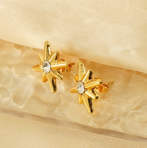 Detailed macro of 18K gold starburst earrings with central sparkling zircon stone