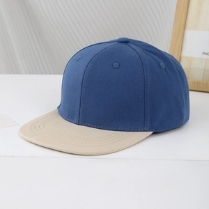 Detail view of kids' two-tone baseball cap featuring navy body and beige flat brim