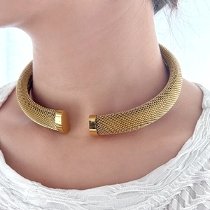 Close-up of a 18K gold plated mesh woven C-shaped open collar necklace on a model