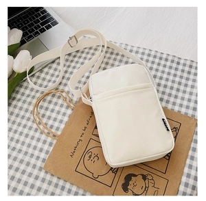 Close-up of white corduroy crossbody bag with front zipper and adjustable shoulder strap