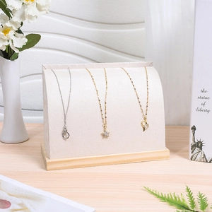 Detail of velvet necklace display stand with solid wood base and cream fabric finish