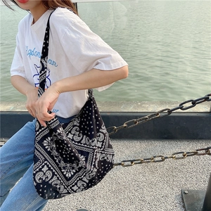 Outdoor shot of a vintage paisley canvas tote bag in black and white ethnic style