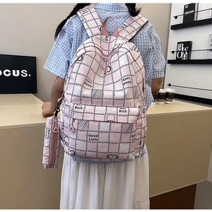 Detail view of pink plaid backpack with matching pencil case and lucky letter patterns