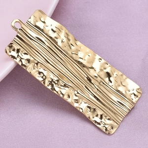 Macro shot of 18k gold plated stainless steel rectangular pendant with hammered texture
