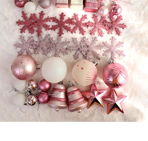 Vue détaillée à plat de boules de Noël roses et blanches sur fond de fausse fourrure