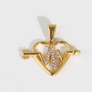 Détail macro du pendentif cœur doré avec flèche et pierres de zircone cubique étincelantes