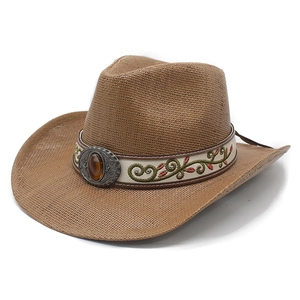 Détail d'un chapeau de cowboy en paille marron avec boucle vintage et pierre ambre