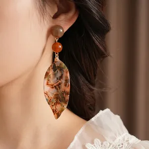 Elegant amber acetate leaf earrings with marbled beads on a gold-plated drop design