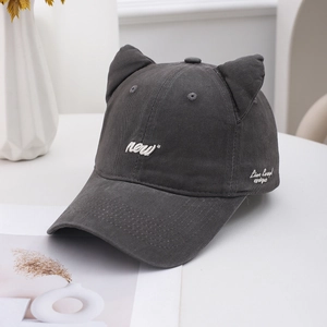 Detailed view of dark grey cat ear baseball cap with white letter embroidery on cotton