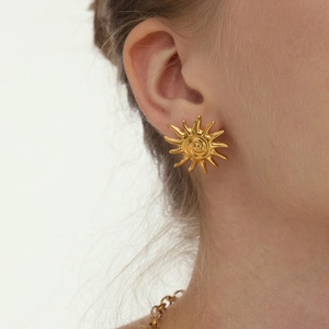 Boucles d'oreilles soleil de luxe en or 18 carats avec rayons sur le modèle