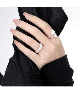 Detail showing brushed silver heart ring and geometric band on model finger