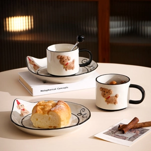 Detail of dog motif ceramic mug and saucer set with 3D teddy dog and bread on the table
