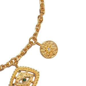 Gros plan détaillé des pendentifs soleil et œil en plaqué or 18K avec pierres colorées