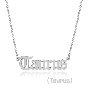 Macro shot of silver Taurus zodiac pendant featuring artistic cursive script lettering