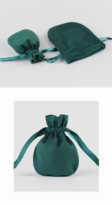Macro shot of dark green velvet drawstring jewelry pouch showing texture and drawstring