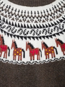 Close-up of Fair Isle knit sweater with brown horse patterns and soft wool texture