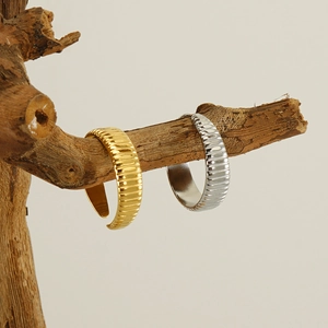 Detailed macro shot of gold and silver textured croissant rings on wooden branches
