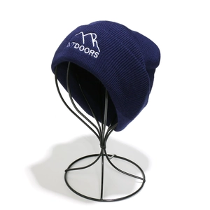 Detail of navy knit beanie featuring white mountain peak embroidery and outdoors text