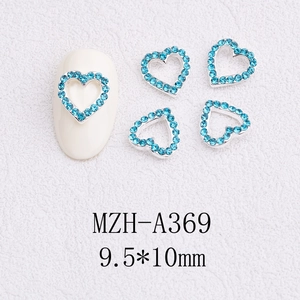 Macro detail of sky blue heart nail charms with silver metal base on white background