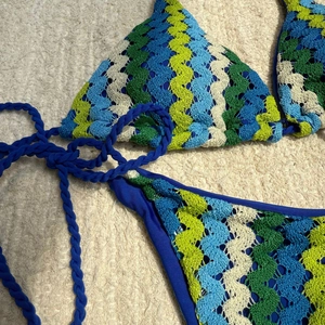 Détail du haut de bikini au crochet bohème avec motif vagues et cordons bleus tressés