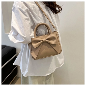 Detail of the oversized bow decoration on the light brown vegan leather handbag