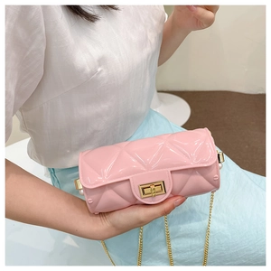Detailed close-up of a pink quilted cylinder bag with gold chain and pearl accents