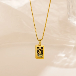 Macro detail of tarot style gold rectangle pendant with star patterns and colorful gems