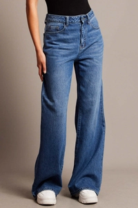Dettaglio della vita alta e del taglio ampio dei pantaloni in denim blu a gamba larga