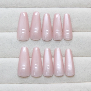 Pink cat-eye press-on nails in long coffin shape with pearlescent finish on velvet box