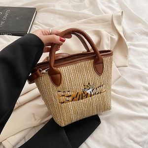 Straw woven tote bag with brown leather handles and tiger embroidery in beige finish