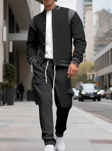 Detail of grey shoulder stitching and textured fabric on a black baseball jacket
