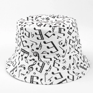 Détail d'un bob en toile blanche avec des notes de musique noires et un motif partition