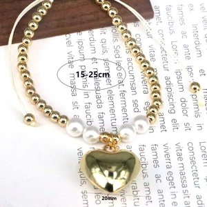 Detail showing adjustable pearl bracelet with 20mm gold heart charm and size labels