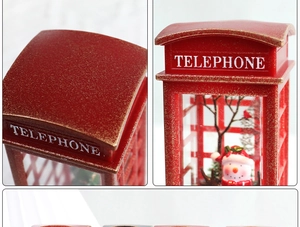 Close-up of a vintage red telephone booth Christmas snow globe with snowman and red bird