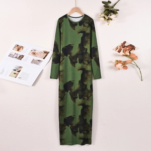 Détail d'une robe midi élégante à imprimé vert et noir sur un cintre en bois