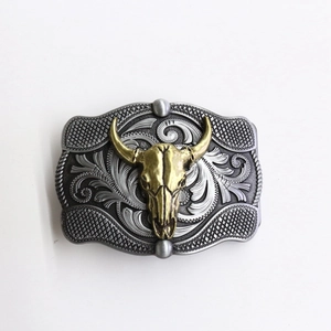 Western cowboy belt buckle with golden longhorn skull and vintage engraved scrollwork