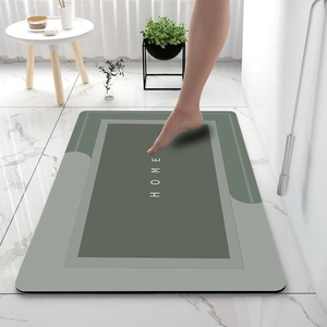 Detail of grey-green diatom mud bath mat with HOME text showing fast water absorption